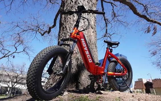 A tourist rides an E-Bike rentals model along the coast.